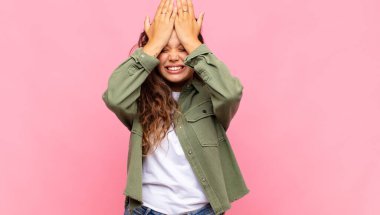 Kadın stresli ve endişeli, depresif ve hayal kırıklığına uğramış hissediyor, iki elini de başa kaldırıyor.