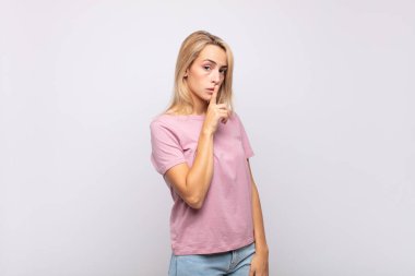 Kadın sessizlik ve sessizlik istiyor, parmaklarıyla ağzının önünde işaret ediyor, 