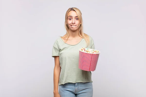 Mladá Žena Popcornským Kbelíkem Zmatená Zmatená Kousající Rtu Nervózním Gestem — Stock fotografie