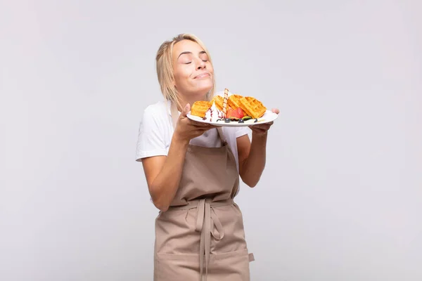 young pretty blonde woman baker. waffle concept