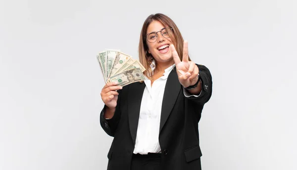 Mujer Joven Con Billetes Sonriendo Mirando Amigable Mostrando Número Dos —  Fotos de Stock