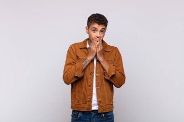  Mutlu ve heyecanlı, şaşırmış ve şaşkın ellerle ağzını kapatmış, tatlı bir ifadeyle kıkırdıyor.