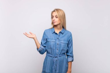 Kadın kendini mutlu hissediyor ve gelişigüzel gülümsüyor. Elinde tuttuğu bir nesneye ya da konsepte bakıyor.