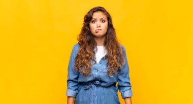 Kadın kendini cahil, kafası karışık ve hangi seçeneği seçeceği konusunda kararsız hissediyor, sorunu çözmeye çalışıyor.