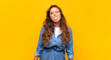 Kadın kendini iğrenç ve rahatsız hissediyor, dilini dışarı çıkarıyor, iğrenç ve iğrenç bir şeyden hoşlanmıyor.