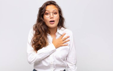 Kadın şok olmuş ve şaşırmış hissediyor, gülümsüyor, el ele tutuşuyor, o olmaktan mutlu ya da minnettarlık gösteriyor.