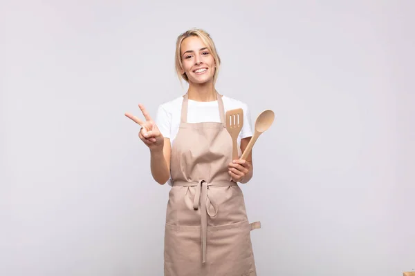 Joven Mujer Chef Sonriendo Buscando Amigable Mostrando Número Dos Segundo —  Fotos de Stock