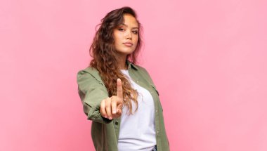 Gururla gülümseyen ve kendinden emin bir şekilde bir numaralı pozu veren bir kadın kendini lider gibi hisseder.