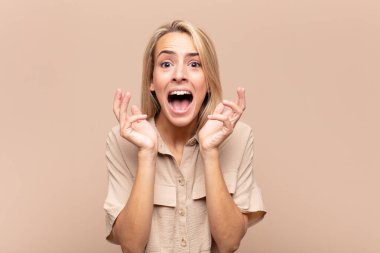 Beklenmedik bir sürpriz yüzünden şaşkın ve heyecanlı, gülen, şaşkın ve mutlu bir kadın.