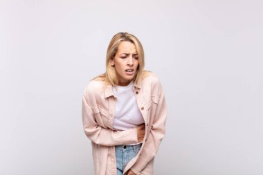 Kadın endişeli, hasta, hasta ve mutsuz hissediyor. Ağrılı bir mide ağrısı ya da grip.