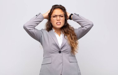 Kadın kendini stresli, endişeli, endişeli ya da korkmuş hissediyor. Elleri başının üstünde, hatayla panikliyor.