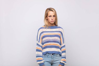 Kadın üzgün, üzgün ya da kızgın ve olumsuz bir tavır takınıyor, anlaşmazlık içinde kaşlarını çatıyor.