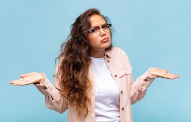 Kadın şaşkın, kafası karışmış ve stresli görünüyor, farklı seçenekler arasında merak ediyor, belirsiz hissediyor.