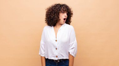 Kadın şaşkın, mutlu, şaşkın ve şaşırmış hissediyor, ağzı açık bir şekilde yana bakıyor.