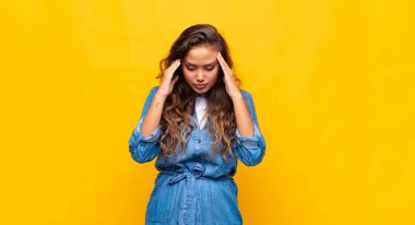 Stresli ve hayal kırıklığına uğramış bir kadın, baskı altında çalışıyor, başı ağrıyor ve sorunları var.