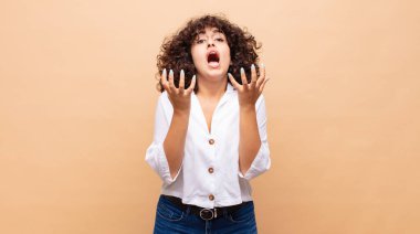 Kadın umutsuz ve sinirli görünüyor, stresli, mutsuz ve sinirli, bağırıyor ve çığlık atıyor.