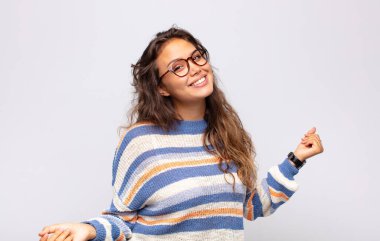 Gülümseyen, kaygısız, rahat ve mutlu hisseden, dans eden ve müzik dinleyen, bir partide eğlenen bir kadın.