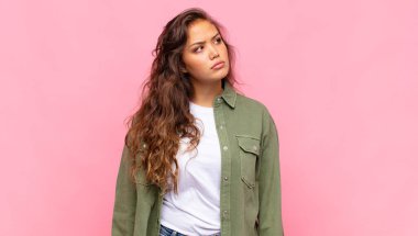 Kadın üzgün, üzgün ya da kızgın ve olumsuz bir tavır takınıyor, anlaşmazlık içinde kaşlarını çatıyor.