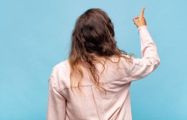 Kadın dikey görünüm ve kopya alanı üzerinde duran ve nesneyi işaret eden