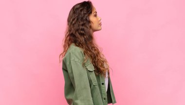 Profil görünümlü bir kadın uzayı kopyalamaya çalışıyor, düşünüyor, hayal ediyor ya da hayal kuruyor.