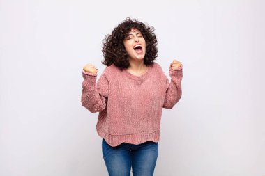 Kadın mutlu, şaşırmış ve gururlu, bağırıyor ve başarıyı büyük bir gülümsemeyle kutluyor.