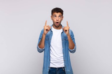  Şaşırmış, şaşırmış ve ağzı açık bir şekilde iki eliyle uzayı kopyalamak için yukarı bakıyor.