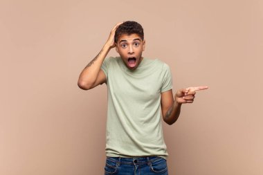  Gülüyor, mutlu, pozitif ve şaşırmış görünüyor. Yan fotokopi alanını işaret eden harika bir fikri fark ediyor.