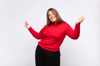 Genç sarışın kadın gülümsüyor, kaygısız hissediyor, rahat ve mutlu, dans ediyor ve müzik dinliyor, bir partide eğleniyor.