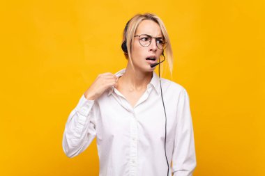 Genç bir kadın tele pazarlamacı stresli, endişeli, yorgun ve hayal kırıklığına uğramış, gömleğini çekiştirmiş, sorunlardan bıkmış görünüyor.