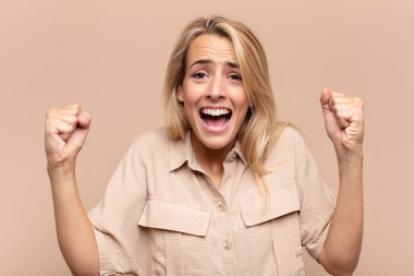 Kadın mutlu, pozitif ve başarılı hissediyor, zaferi, başarıları ya da iyi şansı kutluyor.