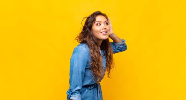 Gülümseyen bir kadın, tuhaf bir şekilde yan tarafa bakıyor, dedikoduları dinlemeye ya da bir sırrı duymaya çalışıyor.