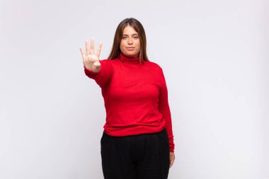 Genç sarışın kadın gülümsüyor ve arkadaş canlısı görünüyor, dört ya da dört numarayı gösteriyor, eli önde, geriye doğru sayıyor.