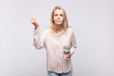young woman with a coffee making capice or money gesture, telling you to pay your debts!