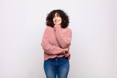 Kadın düşünceli, meraklı ya da hayal kuruyor, hayal kuruyor ve uzayı taklit etmeye çalışıyor.