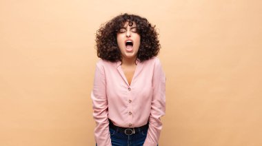 Kadın agresif bir şekilde bağırıyor, çok kızgın, sinirli, öfkeli ya da sinirli görünüyor.