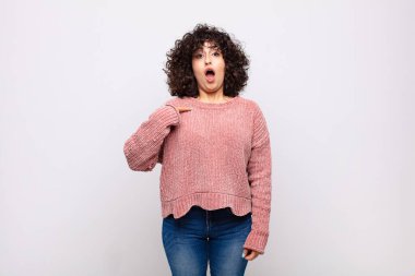 Şok olmuş ve ağzı açık, kendini işaret eden bir kadın.