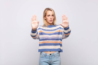 Kadın ciddi görünüyor, mutsuz, kızgın ve hoşnutsuz giriş ya da her iki avuçta da dur diyor.