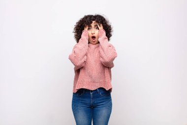 Kadın dehşete kapılmış ve şok olmuş hissediyor, ellerini havaya kaldırıyor ve hata yaptığında panikliyor.