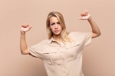 Kadın gururlu, kibirli ve kendinden emin, tatmin olmuş ve başarılı görünüyor, kendini işaret ediyor.