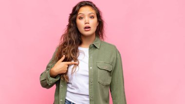 Şok olmuş ve ağzı açık, kendini işaret eden bir kadın.