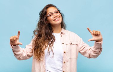 Kendi gülüşünü çizen ya da çerçeveleyen kadın iki eliyle, olumlu ve mutlu görünüyor, sağIık kavramı