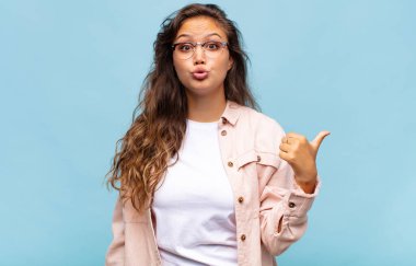 Kadın inançsızlıktan şaşkın şaşkın bakıyor, yan taraftaki objeyi işaret ediyor ve diyor ki: