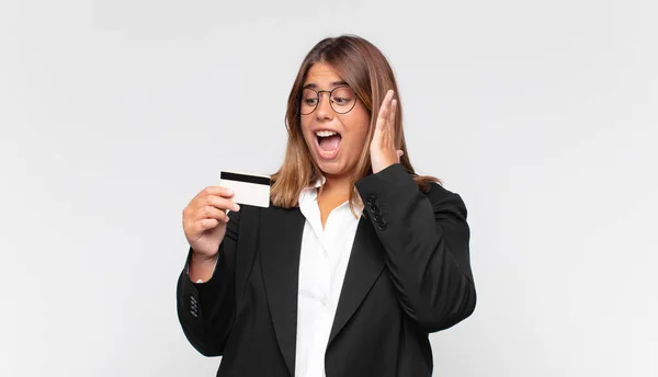 Młoda Kobieta Kartą Kredytową Uczucie Szczęśliwy Podekscytowany Zaskoczony Patrząc Bok — Zdjęcie stockowe