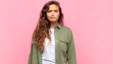 Kadın kendini şaşkın ve şüpheli hissediyor, merak ediyor ya da karar vermeye çalışıyor.