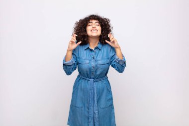 Kadın gergin ve umutlu, şans diliyor ve dua ediyor.