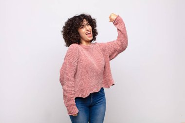 Kadın kendini mutlu, tatmin olmuş ve güçlü hissediyor, kaslı ve formda, spor salonundan sonra güçlü görünüyor.