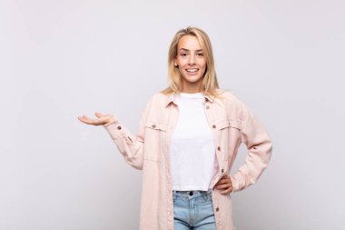 Gülümseyen, kendinden emin, başarılı ve mutlu hisseden bir kadın, fotokopi alanında fikir veya konsept gösteriyor.