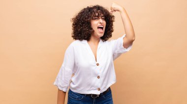 Kadın kendini mutlu, tatmin olmuş ve güçlü hissediyor, kaslı ve formda, spor salonundan sonra güçlü görünüyor.