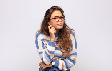 Stresli, hayal kırıklığına uğramış ve yorgun hisseden bir kadın endişeli ve sorunlu bir bakışla boynunu ovalıyor.