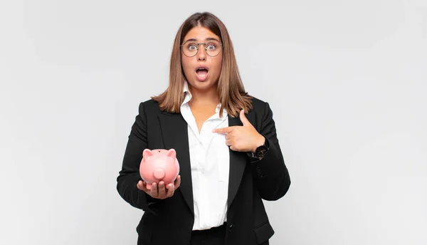 Young Woman Piggy Bank Looking Shocked Surprised Mouth Wide Open — Zdjęcie stockowe